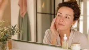 Kobieta sprawdza skórę twarzy po nałożeniu serum z mikroigłami